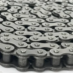 Close-up of overlapping silver chain links with riveted pins, forming an interlocking pattern.